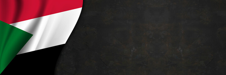 Sudan flag on concrete wall. Banner with fabric texture of the flag of Sudan