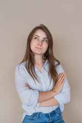 Young girl isolated on beige background shows standing thoughtfully
