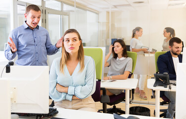 Irritated boss scolding unhappy female subordinate pointing out shortcomings and misses in work