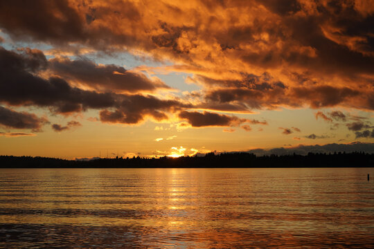 sunset over the lake with clouds in the sky