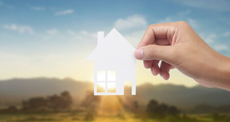 Hands holding paper house, family home  protecting insurance concept