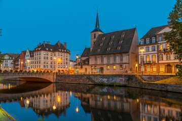 Sunset view of waterfront of a channel passing Saint Nicholas church of Strasbourg, France