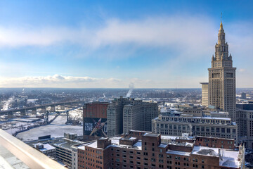 View over the Western part of Cleveland with a frozen Cuyahoga River and several downtown buildings including the Terminal Tower. 