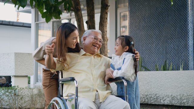 Disabled Senior Grandpa On Wheelchair With Grandchild And Mother In Park, Happy Asian Three Generation Family Having Fun Together Outdoors Backyard, Grandpa And Little Child Smiling And Laughed