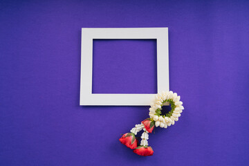 Thai Flower Garland with jasmine & roses with white frame over purple background.