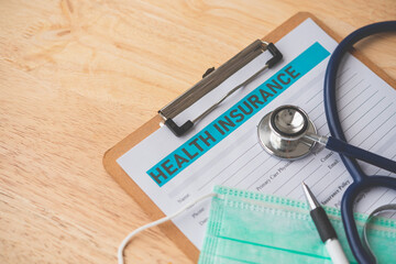 Stethoscope and calculator placed on health insurance documents, Individual medical health...