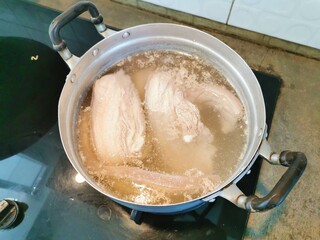 Boil pork in a pot on a gas stove
