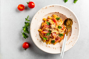 Pasta with cherry tomatoes, cheese and chicken meat on a light background. Pasta al Pomodoro. Italian food. Top view