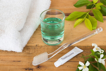Obraz na płótnie Canvas toothbrush ,toothpaste ,terry clothes ,mouthwash for health care oral cavity arrangement flat lay style on background wooden