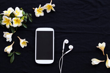 mobile phone and flower frangipani arrangement flat lay style on background black 