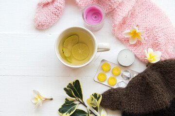 herbal honey lemon healthy drinks health care for sore throat ,lozenge with pink  knitting wool scarf of lifestyle woman relax in winter season and flowers frangipani arrangement flat lay style 