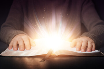 Woman reading magic book on dark background