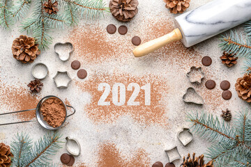 New Year composition with cookie cutters and cacao powder on grey background