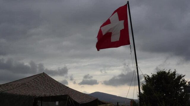 Aid station, field hospital. Surgical care to the wounded in the war. Red cross flag in the wind on mobile medical camp