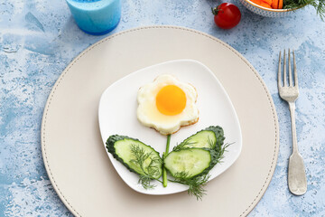 Creative breakfast for children with egg and fresh vegetables on color background, closeup