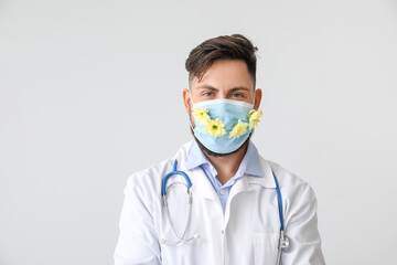 Allergist wearing facial mask with flowers on light background