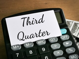 Economy and business concept. Phrase Third quarter  written on white card with calculator,fake...