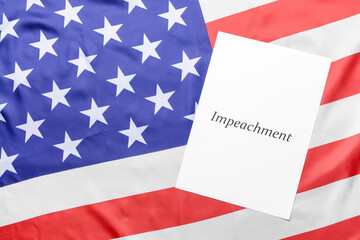 Fototapeta na wymiar Paper with word IMPEACHMENT on USA flag