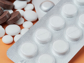 various white tablets on an orange background