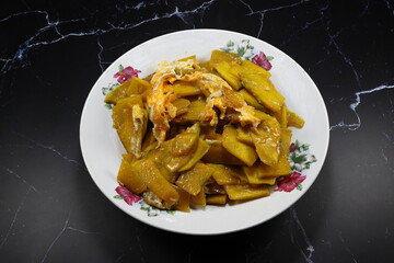 Traditional fried and stirred fresh sliced pumpkin meat with egg serving on the plate. High fiber and vitamin food.