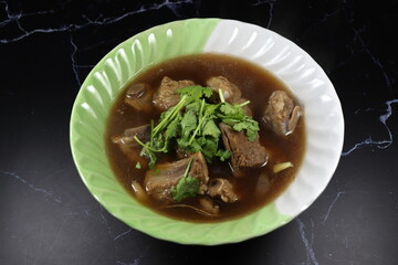 Classic gravy soup of pork rib topping with fresh coriander serving in the bowl. Famous hot soup menu in Asia restaurant. 