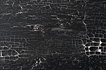 wood covered with black craquelure varnish.