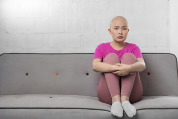 Portrait of sad Asian woman cancer patient after suffering serious hair loss due to chemotherapy