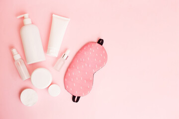Daily skin care concept. Sleep mask with cosmetic product on pink pastel background. Top view, flat lay, copy space