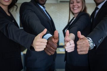 The management team in the company extended their thumbs together. 