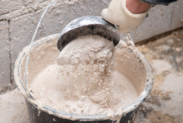 A worker kneads the mixture into plaster buckets. Home renovation
