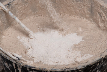 A worker kneads the mixture into plaster buckets. Home renovation