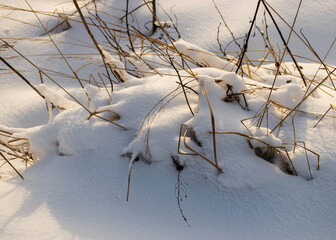 abstract snow texture, snow and frozen grass, shadows on the snow