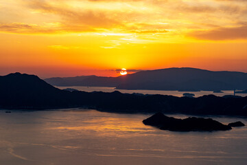 オレンジ色の夕焼けと海面に映る夕日