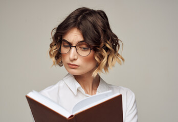 Literate woman with book in hands and in glasses white shirt education model