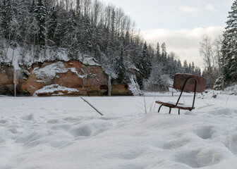 Scenic and impressive up to 600 m long and 21 m high outcrop on the river bank. The snow is covered by a river and a rock. It consists of reddish-brown sandstone outcrops of the Gauja suite.