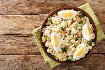 Delicious potato salad with eggs with cream dressing close-up in a bowl on the table. horizontal...