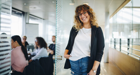 Smiling business executive outside office boardroom