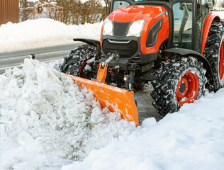 The tractor cleans the sidewalk in winter