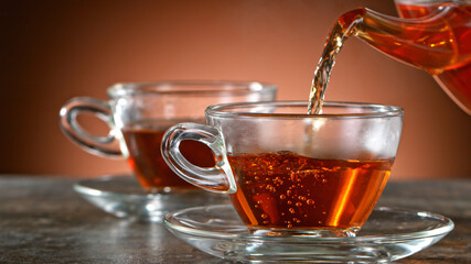 pouring tea to a teacup, close-up