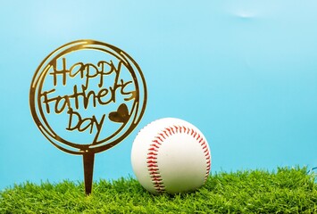 Baseball with Happy Father's Day sign on green grass