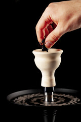 Fototapeta na wymiar Ceramic tobacco bowl of hookah on black background