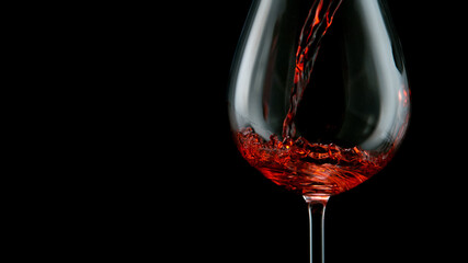 Detail Shot of Pouring Red Wine from Bottle isolated on black.