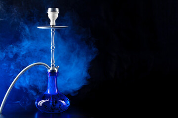 Modern hookah with smoke in dark club light