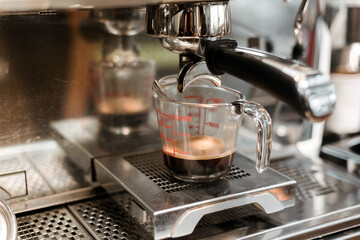 black coffee in measuring cup put on coffee maker