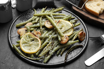 Delicious baked green beans served on black table