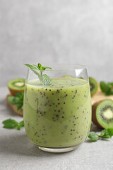 Delicious kiwi smoothie on light grey table