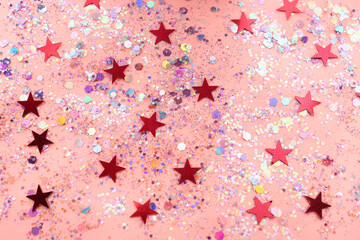 Shiny glitter on light pink background, above view