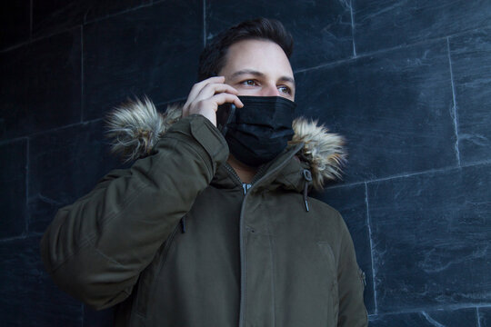 man with medical mask on the street using mobile phone