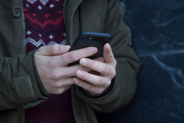 man using smartphone on street wall background