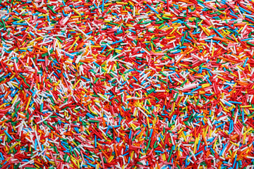 Fototapeta premium Bright colorful sprinkles as background, top view. Confectionery decor